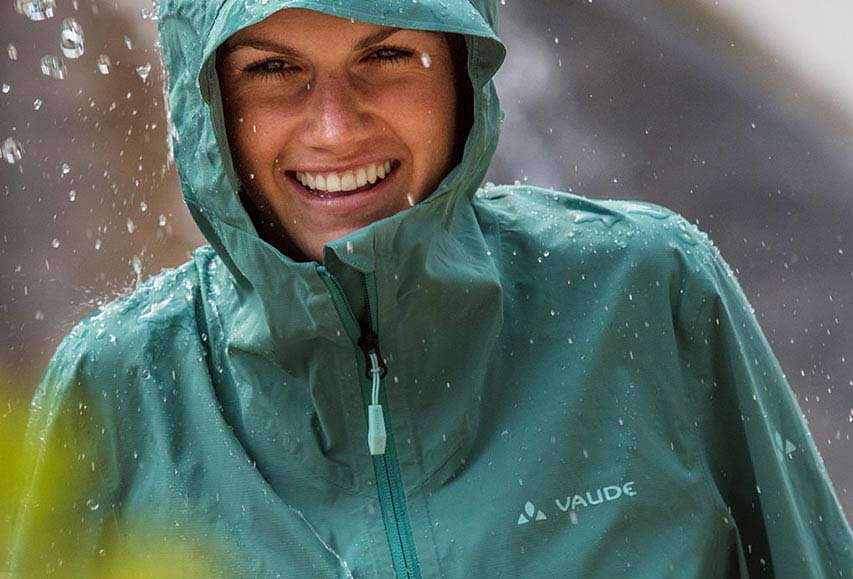 PFAS-Ausstieg bei VAUDE Frau mit grüner Regenjacke von VAUDE im Regen