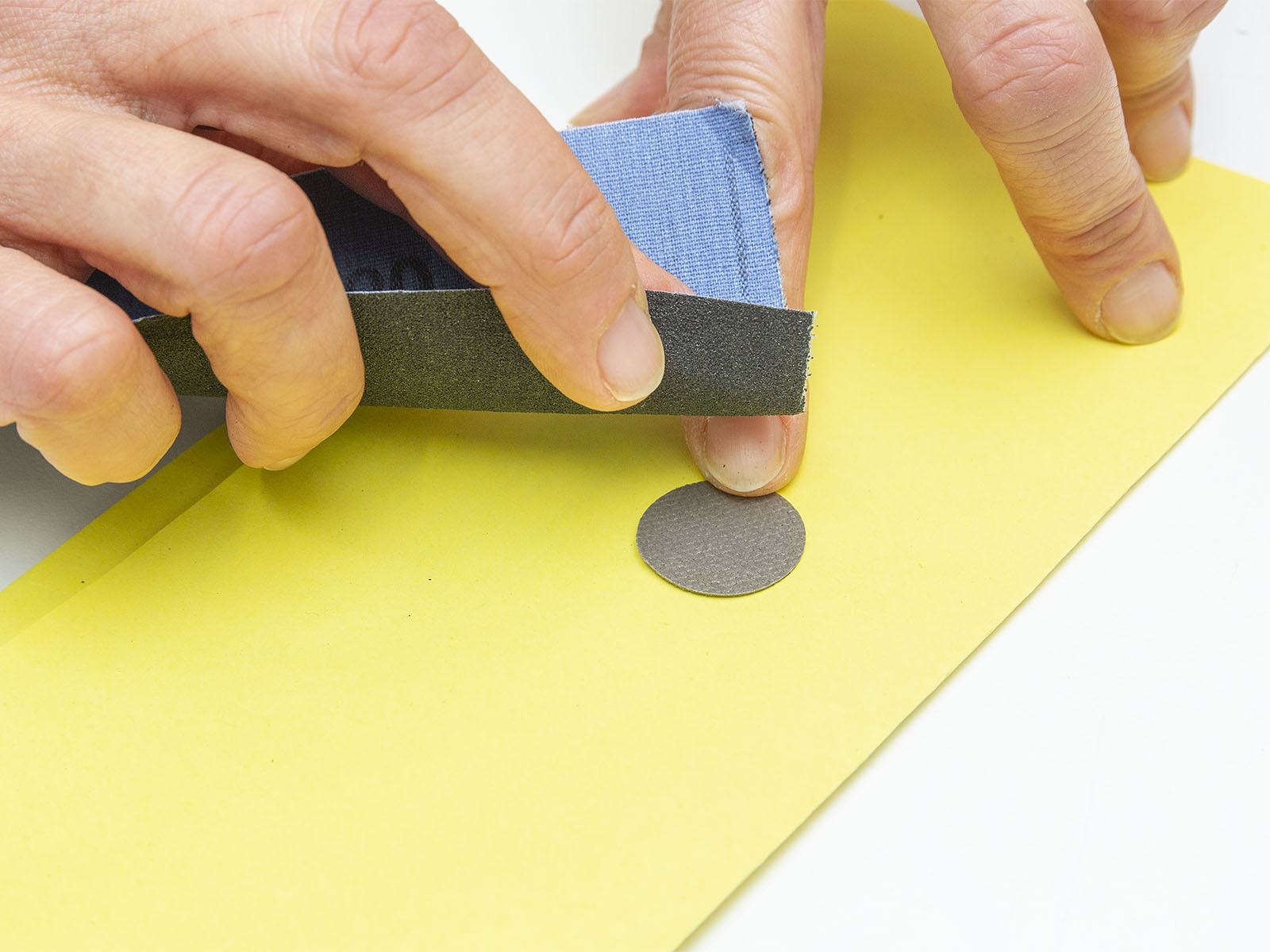Mit einem Schleifpapier werden die späteren Klebeflächen angeraut