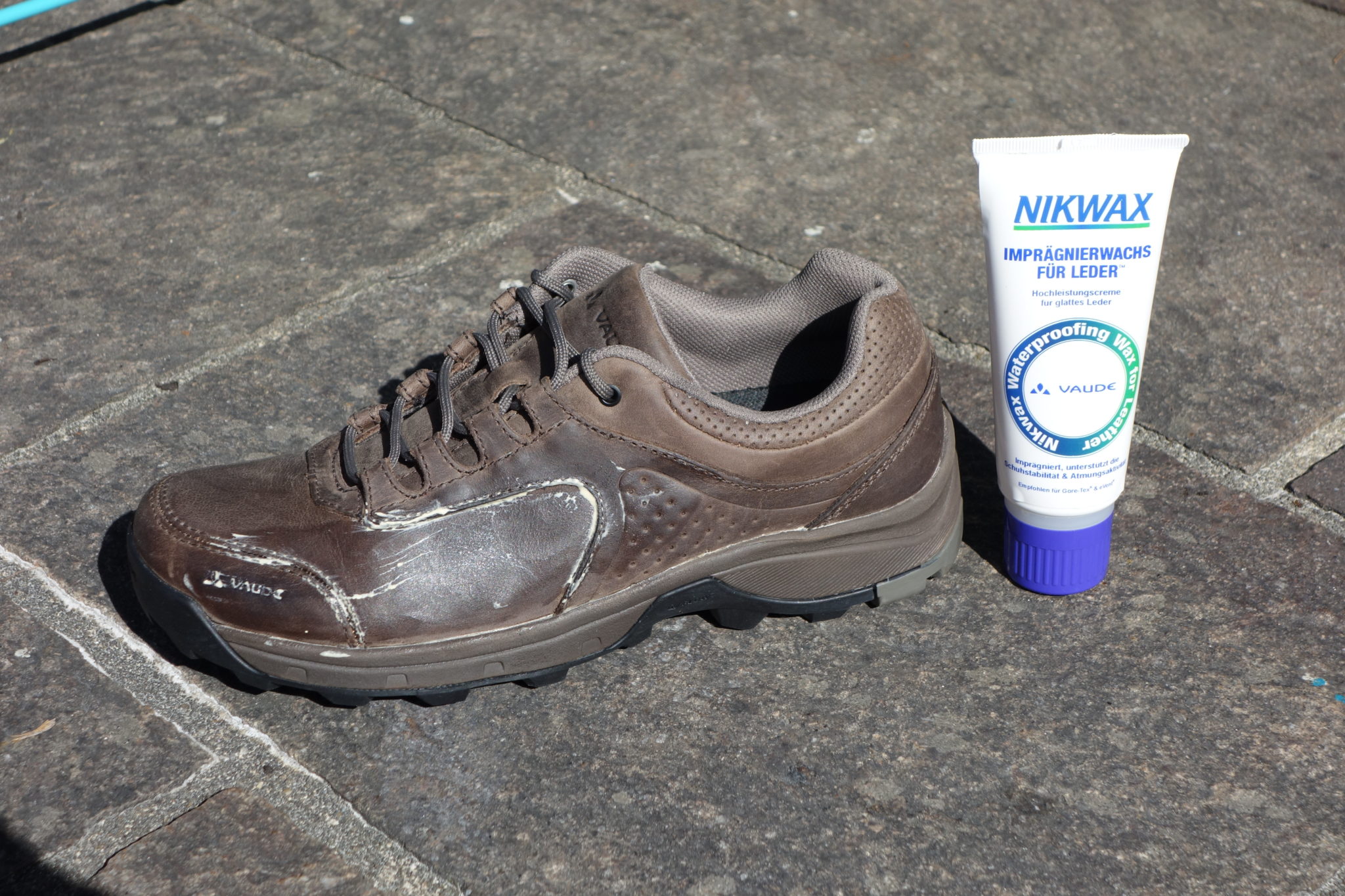 Ein Schuh und ein Nikwax-Imprägnierwachs