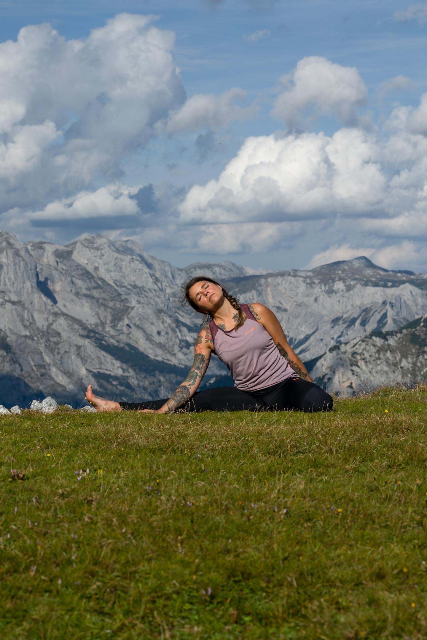 Junge Frau mit Yoga-Pose vor Bergkulisse